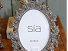 Photograph frame, oval, grey with flower effect.